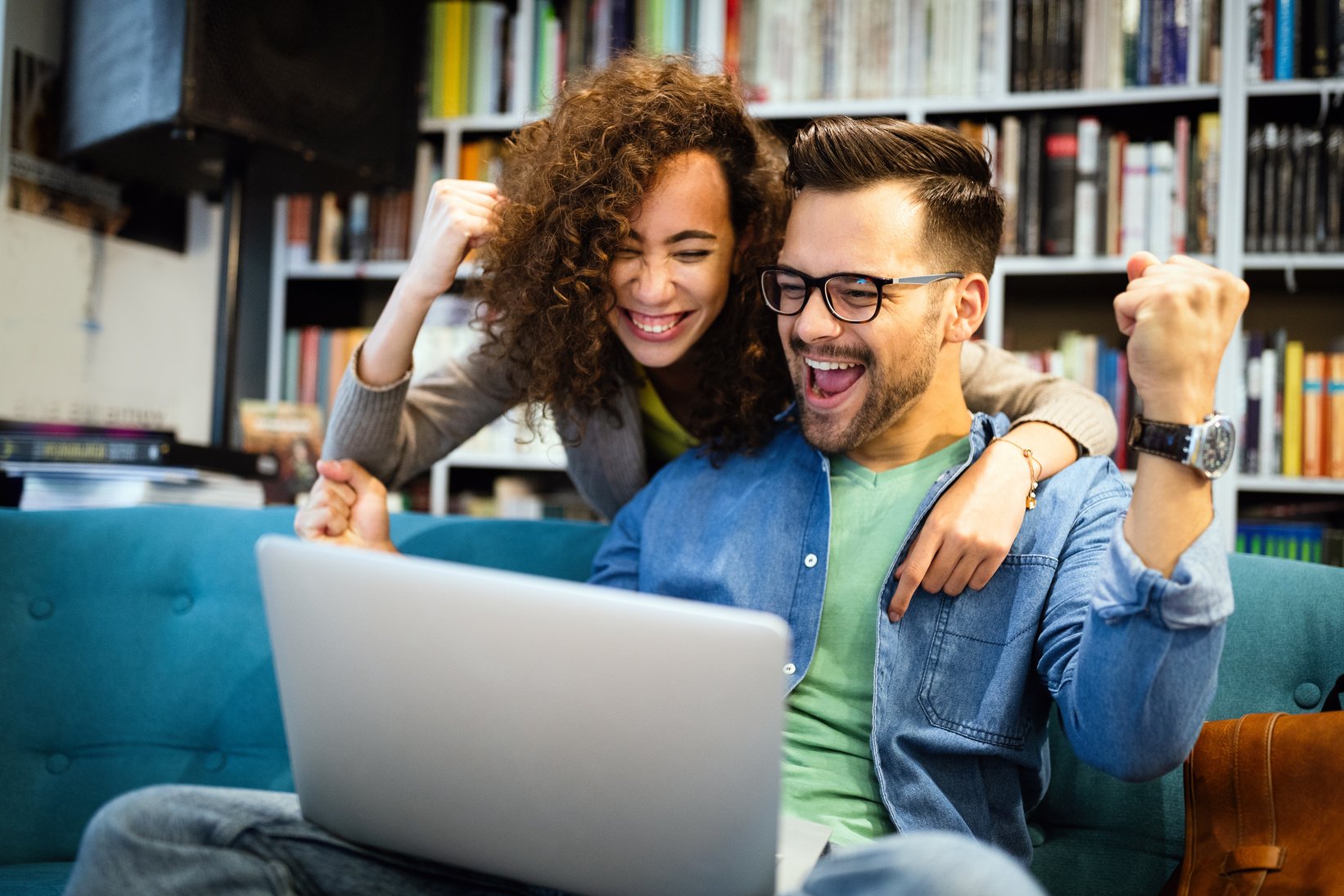 Surprised happy young couple looking at laptop